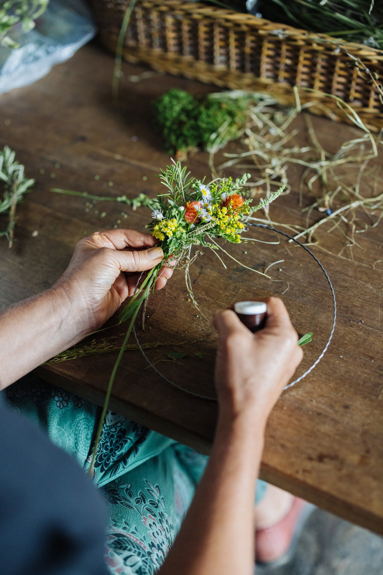 Frau bindet Blumenkranz