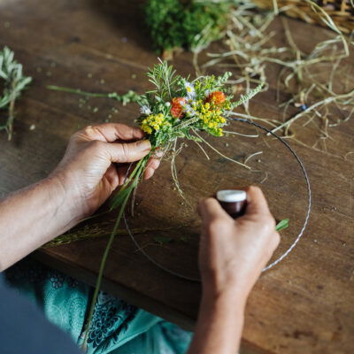 Frau bindet Blumenkranz