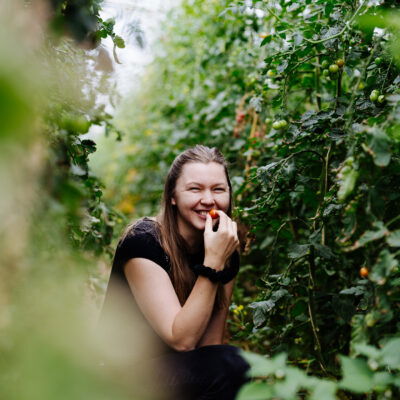 Bäuerin zwischen Tomatenpflanzen