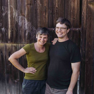 Biobäuerin und Biobauer vor Scheune