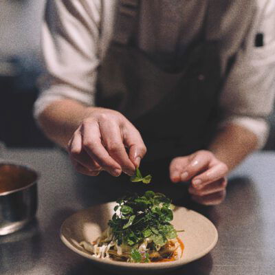 Szegediner Kraut mit Unkrautsalat und Holunderblüte auf Teller