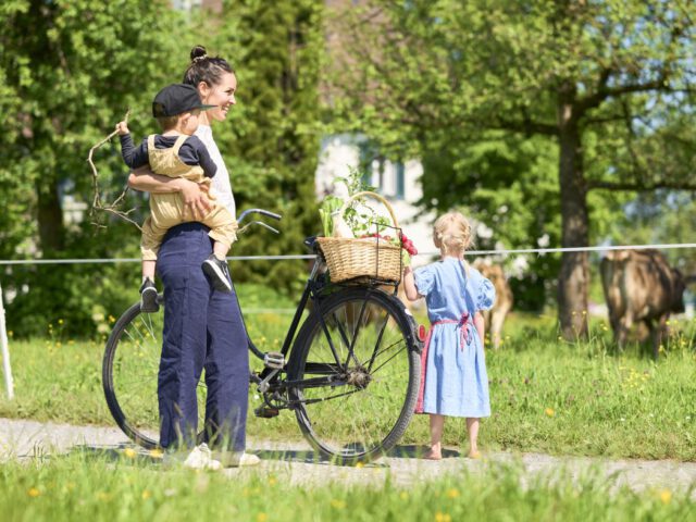 © Ivo Vögel Frau mit Fahrrad, Einkaufskorb mit Lebensmitteln und Kindern