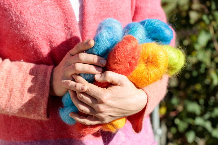 Frau mit bunter Wolle in den Händen