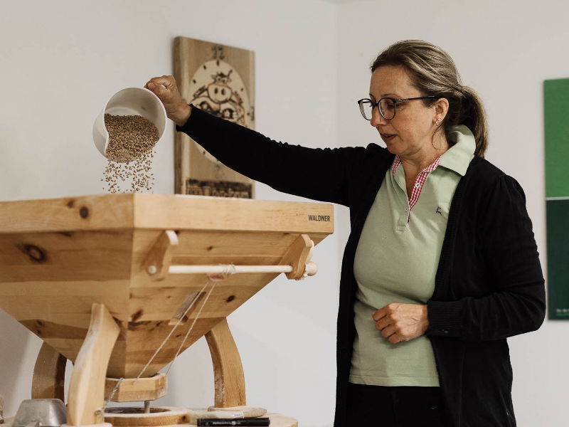 Biobäuerin mit Getreidemühle