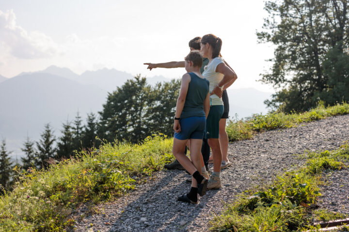 Drei Personen stehen in der Landschaft und Blicken in die Ferne. Ankündigungsbild für Bio-Stammtische Vorarlberg