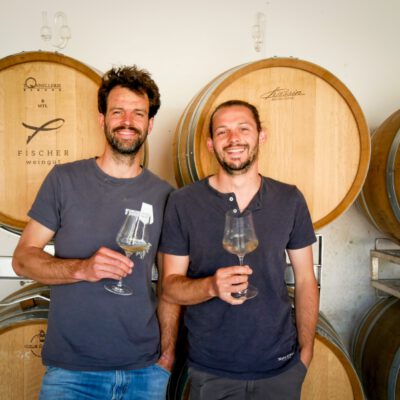 Klaus und Bernhard Fischer mit Weingläsern